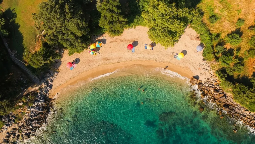 Πανοραμική εναέρια θέα της μικρής παραλίας Πηγάδι στην Αγιά Λάρισας, με πυκνή βλάστηση που φτάνει ως το κύμα.