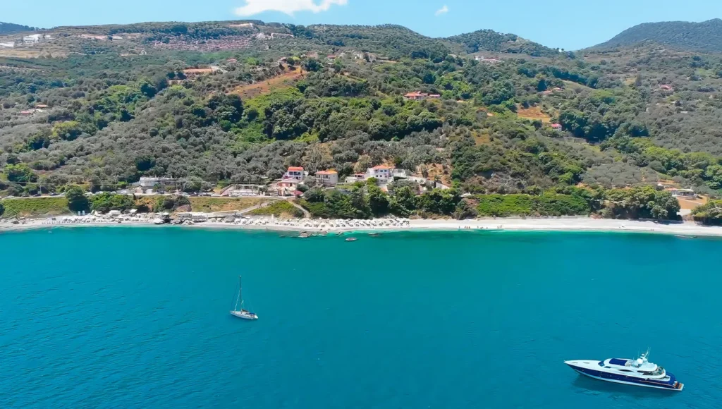 Εναέρια λήψη της οργανωμένης παραλίας Μπούκα (Βραχάκια) στη Λάρισα, με ομπρέλες και γαλαζοπράσινα νερά.