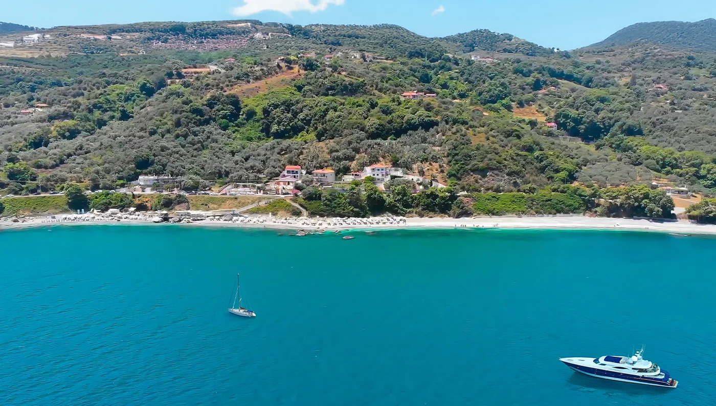 Εναέρια λήψη της οργανωμένης παραλίας Μπούκα (Βραχάκια) στη Λάρισα, με ομπρέλες και γαλαζοπράσινα νερά.