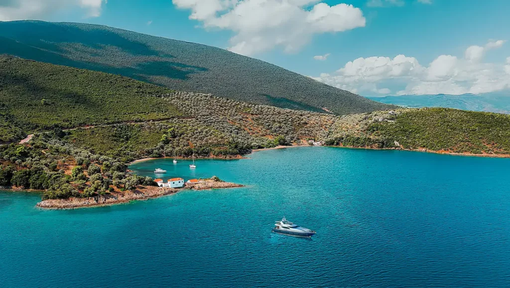 Πανοραμική θέα του παραδοσιακού οικισμού στην Τζάστενη Πηλίου με τα λευκά σπίτια να ακουμπούν στα γαλαζοπράσινα νερά του Παγασητικού.