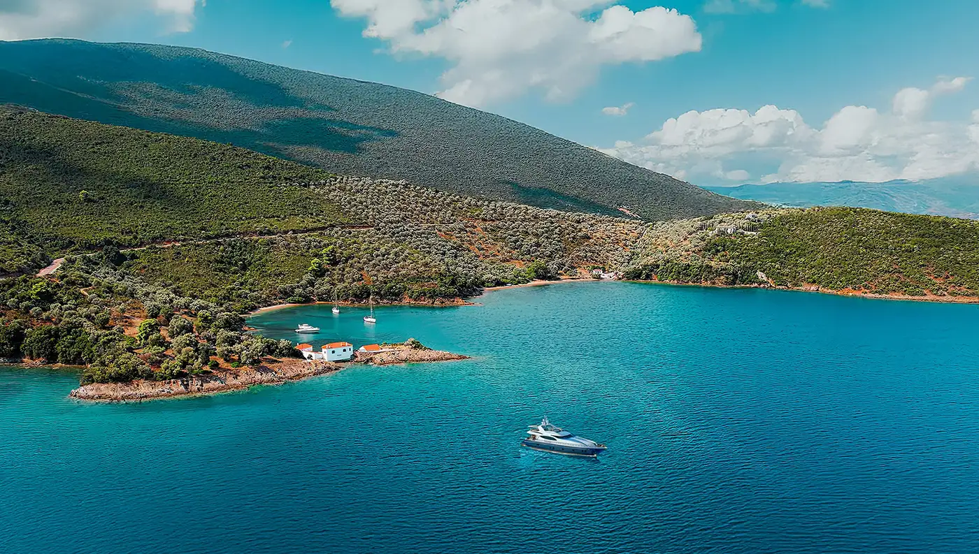 Πανοραμική θέα του παραδοσιακού οικισμού στην Τζάστενη Πηλίου με τα λευκά σπίτια να ακουμπούν στα γαλαζοπράσινα νερά του Παγασητικού.