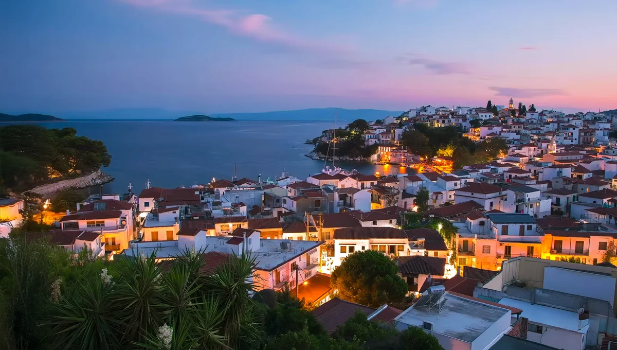 Νυχτερινή άποψη της Χώρας Σκιάθου με φωτισμένα σπίτια και θάλασσα