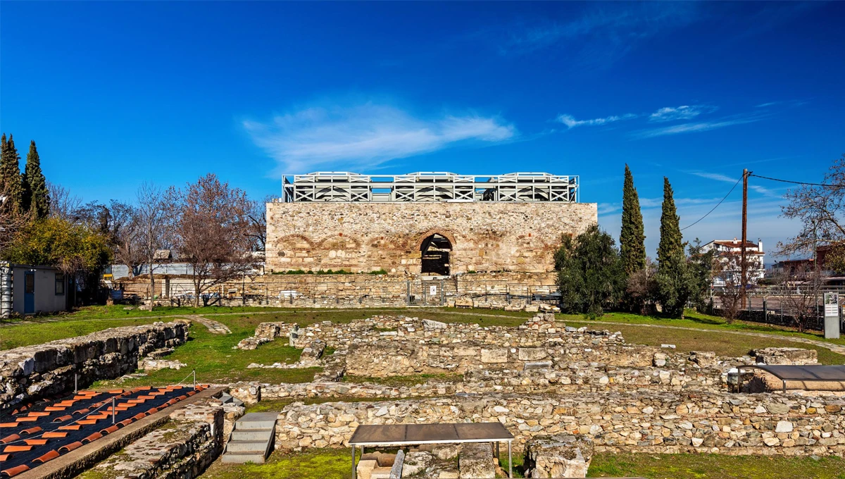 Το ιστορικό Bedesten (Οθωμανική Αγορά) της Λάρισας, ένα πέτρινο κτίριο με θόλους, περιτριγυρισμένο από αρχαιολογικά ευρήματα.