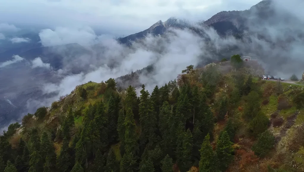 Πανοραμική θέα από το παρατηρητήριο στη λίμνη Πλαστήρα, με δάση, σύννεφα και ορεινό τοπίο