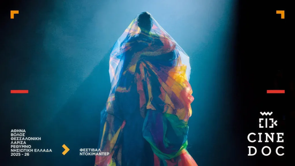Αφίσα του Φεστιβάλ Ντοκιμαντέρ CineDoc 2025-26. Στο κέντρο δεσπόζει μια μορφή καλυμμένη με πολύχρωμα, διάφανα υφάσματα σε σκούρο, μυστηριώδες φόντο.