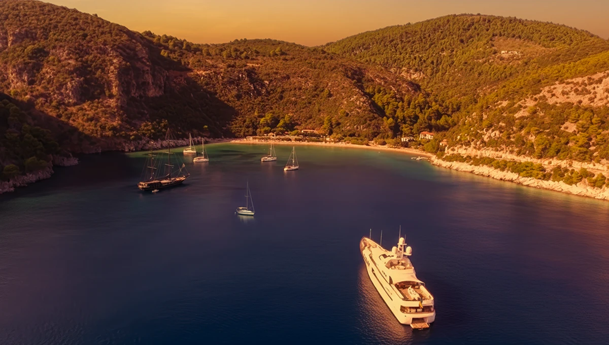 Παραλία Λιμνονάρι στη Σκόπελο, γαλάζια νερά και πράσινος λόφος