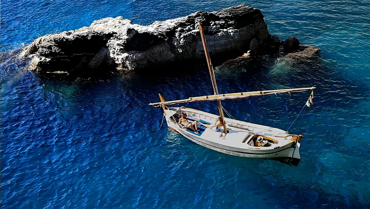 Παραλία της Σκιάθου με βάρκα αραγμένη δίπλα σε βράχο και θάλασσα