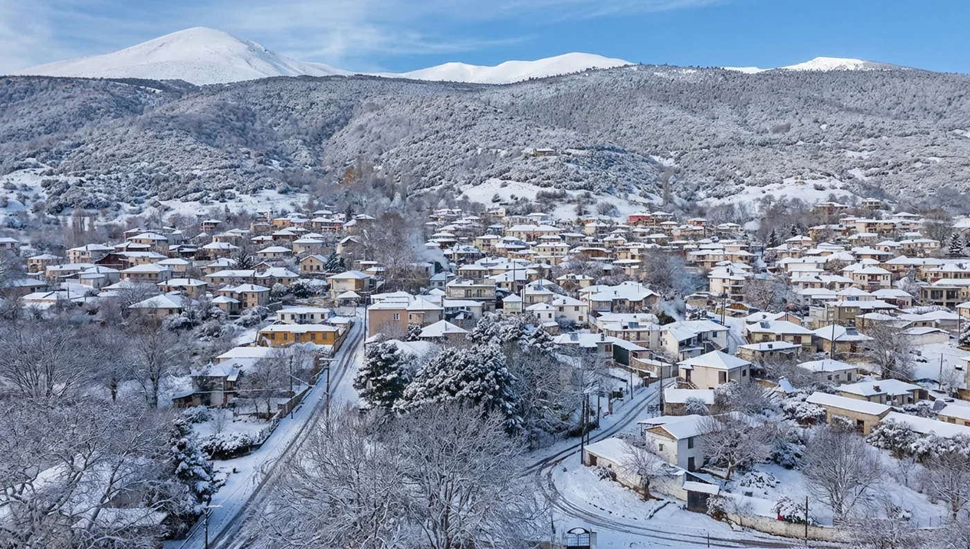 Χιονισμένη Καρυά Ολύμπου με παραδοσιακά σπίτια και χειμωνιάτικο τοπίο