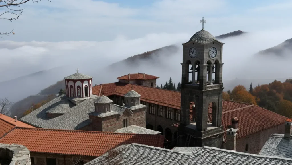 Πανοραμική άποψη της Ιεράς Μονής Κορώνης στην Καρδίτσα με το πέτρινο καμπαναριό και ομίχλη στα βουνά των Αγράφων.