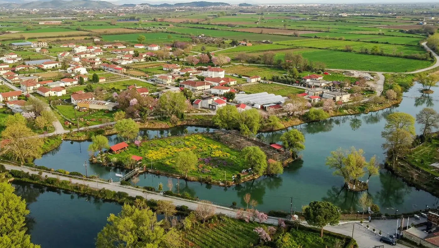 Εναέρια λήψη της καταπράσινης Λίμνης Γκιτζή στο Κεφαλόβρυσο Τρικάλων με τα δέντρα να καθρεφτίζονται στο νερό.