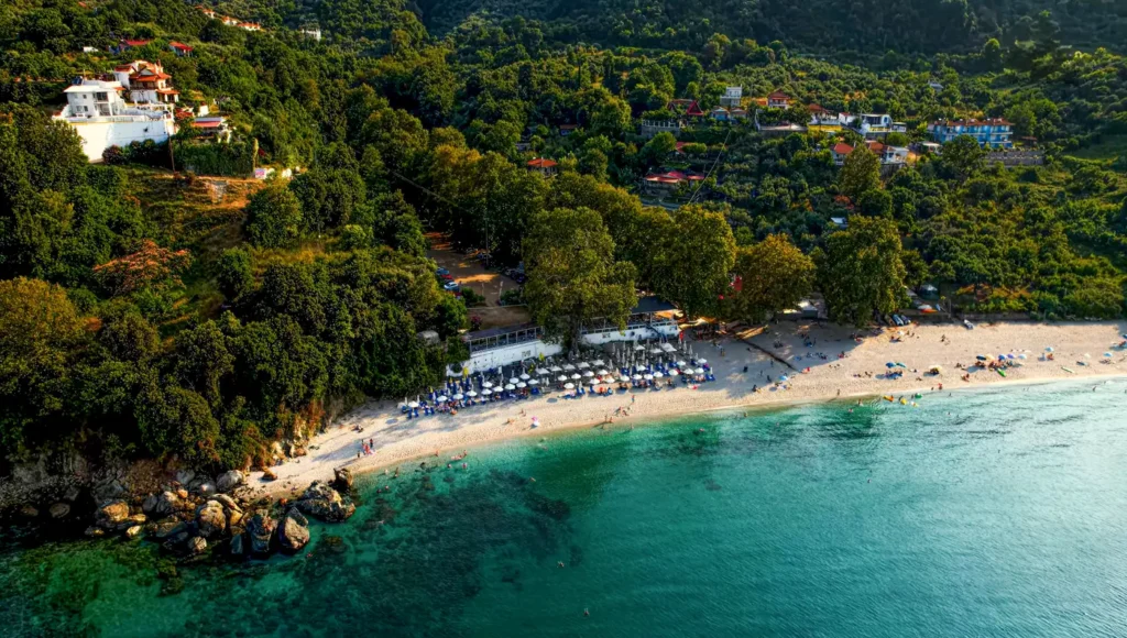 Πανοραμική εναέρια λήψη της παραλίας Πλατιά Άμμος στη Λάρισα, όπου το καταπράσινο βουνό συναντά τα γαλαζοπράσινα νερά.
