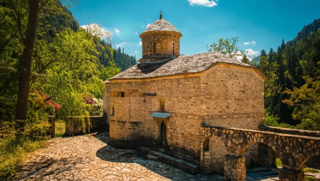 Εξωτερική άποψη από το πέτρινο καθολικό της Μονής Παναγίας Γαλακτοτροφούσας ανάμεσα στα έλατα στην Ανθούσα.