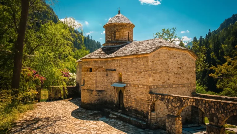 Εξωτερική άποψη από το πέτρινο καθολικό της Μονής Παναγίας Γαλακτοτροφούσας ανάμεσα στα έλατα στην Ανθούσα.