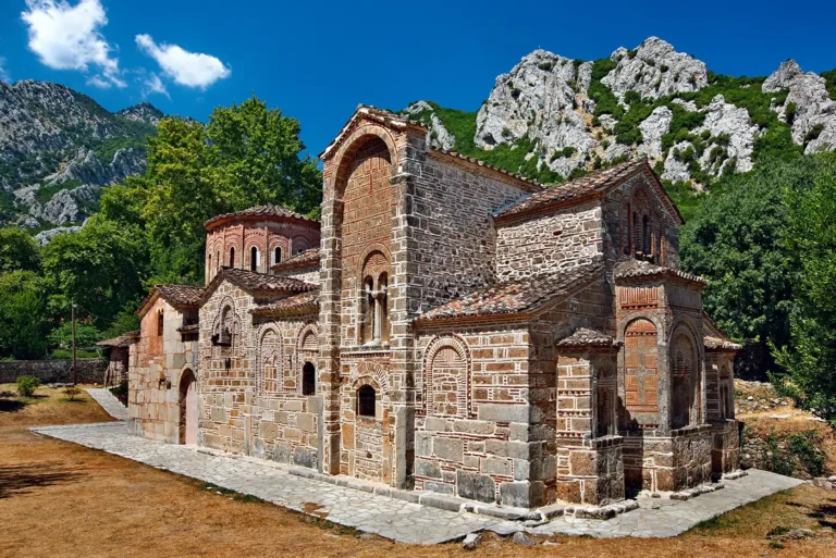 Πετρόχτιστος βυζαντινός ναός της Πόρτας Παναγιάς του 13ου αιώνα στην Πύλη Τρικάλων, περιτριγυρισμένος από βουνά.